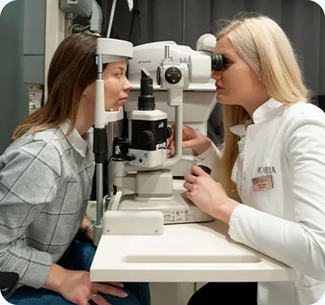 A clinician performing a slit-lamp eye examination on a patient at Morela Okulisti.